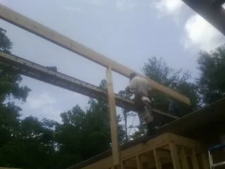 Carpenter setting a ridge beam over a new addition frame — Ice Dam Removal by Roofing Brothers in Mallory