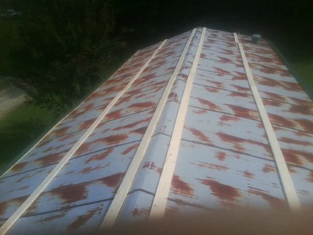 Rusted metal roof panels with new wood purlins before replacement — Storm Damage Roof Repair in Mallory by Roofing Brothers
